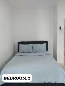 a bedroom with a bed with a white at Alur Homestay Villa 4 Bedrooms in Lahad Datu
