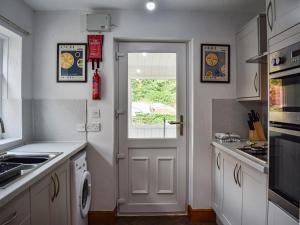 a kitchen with a white door and a window at Tynedale in Keswick
