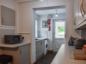a kitchen with a sink and a washing machine at Tynedale in Keswick