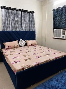 a bed with a blue headboard with flowers on it at 3 Bhk Air Deck luxury apartment in Patna