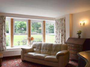 a living room with a couch and a large window at Liverton Lodge Farmhouse in Skinningrove