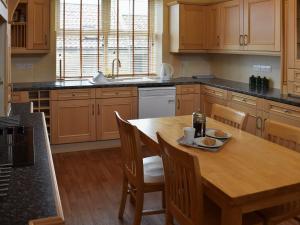 a kitchen with a wooden table and wooden cabinets at Liverton Lodge Farmhouse in Skinningrove