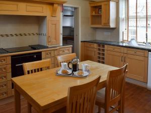 a kitchen with a wooden table with a plate of food on it at Liverton Lodge Farmhouse in Skinningrove +14 photos