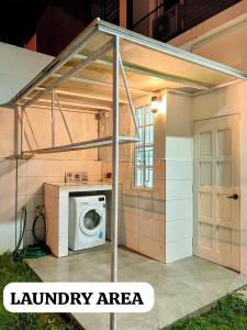a laundry area with a washing machine in it at Alur Homestay Villa 4 Bedrooms in Lahad Datu