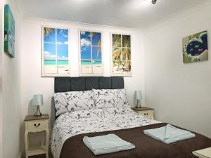 a bedroom with a bed with a view of the beach at Roland Cottage in Falmouth +10 photos