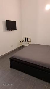 una camera da letto con un letto e una TV a parete di CROCIFERIHOLIDAYhome a Catania