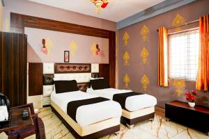 バンガロールにあるHotel O SAS ROYAL GALAXYのベッドルーム1室(ベッド2台、デスク付)