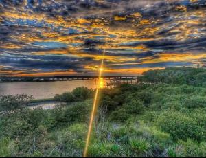 a sunset over a body of water with a bridge at Sunset Sights Waterfront BBQ Fire Pit Dolphins in Saint Augustine
