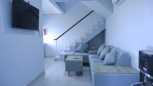 a living room with blue furniture and a staircase at Villa Dalia Puncak CCC9-26 in Cikujang