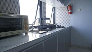 a kitchen counter with a sink and a microwave at Villa Dalia Puncak CCC9-26 in Cikujang