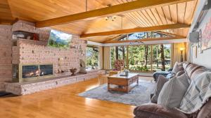 a living room with a fireplace and a stone wall at Panorama Vacation Home by Estes Park Homes home in Estes Park