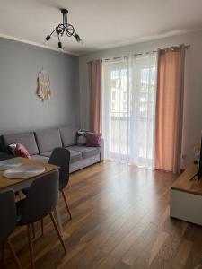salon z kanapą i stołem w obiekcie Apartament Miłosz w mieście Ełk