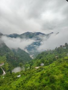 a view of a mountain with clouds in the valley at Snow View Guest House in Kulu