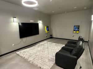 Willow e-hotel في Mattoon: غرفة معيشة بها أريكة وتلفزيون بشاشة مسطحة