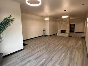 Willow e-hotel في Mattoon: غرفة فارغة بها مدفأة وغرفة بها نبات