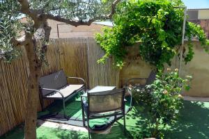 two chairs and a table under a tree in a yard at Stranizza D'amari in Casa Santa