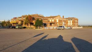 una sombra de una persona tomando una foto de un edificio en Hotel Reina Isabel, en Lleida