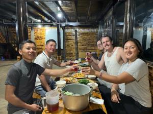 a group of people sitting around a table eating food at Sapa Guide Homestay & Trekking in Lao Cai