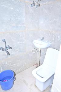une salle de bain avec des toilettes blanches et un lavabo dans l'établissement Hotel Shiva Palace, à Khātu