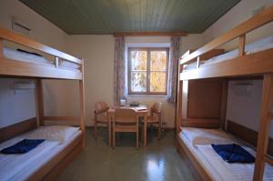 a room with a table and four bunk beds at Junges Hotel Zell am See in Zell am See