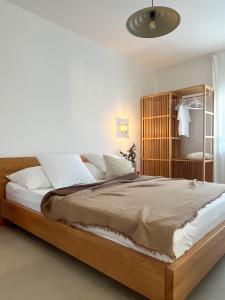 a bedroom with a large bed with a wooden headboard at Lukenda Rooms - Boutique Apartments with view of Adriatic Sea in Pakoštane