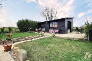 a small black cabin with a patio and a table at Chez patricia in Ploubazlanec