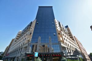 a tall building with glass windows on a city street at Green Garden Apartments in Yerevan