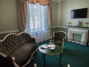 un soggiorno con un divano, un tavolo e una sedia di Maison Elysée a Sibiu