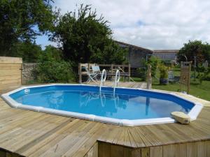 una piscina en una terraza de madera con una piscina en la parte superior en La Cadournaise, en Saint-Seurin-de-Cadourne