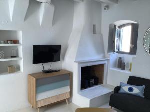 a living room with a tv and a fireplace at La Maison de Bella in Lefkes