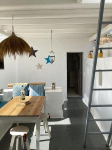 a living room with a wooden table and a ladder at La Maison de Bella in Lefkes