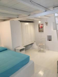 a bedroom with a bed and a cabinet and a chair at La Maison de Bella in Lefkes