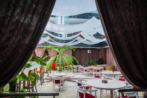 a restaurant with tables and chairs and a ceiling at Mark Plaza Hotel in Mykolaiv