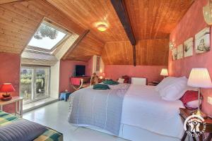 a bedroom with a large bed with a wooden ceiling at Le clos des hortensias in Plémy