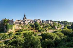 a town on a hill with trees and a road at Le clos des hortensias in Plémy