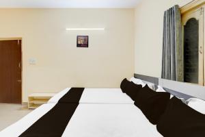a bed with black and white sheets in a room at Hotel O Bluestar in Bengaluru