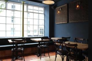 a restaurant with wooden tables and chairs and a large window at The Tilman in Barmouth