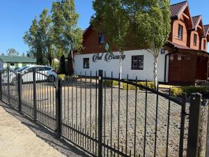 a black fence in front of a white building at Pod brzozą in Chłopy