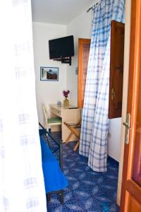a room with a blue and white curtain and a table at La Sirena in Panarea