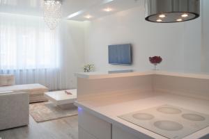 Sofia Apartment في بودابست: غرفة معيشة بيضاء مع أريكة وتلفزيون