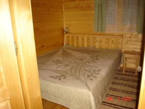 1 dormitorio con 1 cama en una habitación de madera en Romantyk vendégház, en Mánfa
