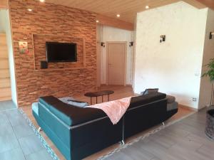 a living room with a couch and a brick wall at Le coin de paradis du Haut-Jura in Fort-du-Plasne