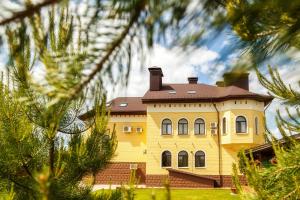 イジェフスクにあるSosnoviy Bor Guest Houseの茶色の屋根の大黄色い家