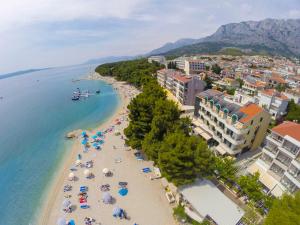 an aerial view of a beach with umbrellas and the ocean at Hotel Milenij in Makarska