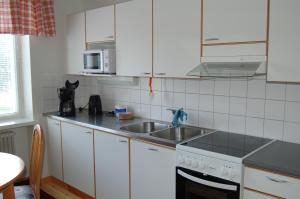 eine Küche mit weißen Schränken und einem Waschbecken in der Unterkunft Apartementos Saukkohaka in Ristijärvi