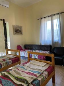 a room with two beds and a couch at Németh Apartman Palić in Palić