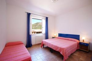 a bedroom with two beds and a window at Nisportino Domus in Rio nellʼElba