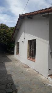 ein weißes Gebäude mit zwei vergitterten Fenstern in der Unterkunft casa en escobar con cocheras in Belén de Escobar