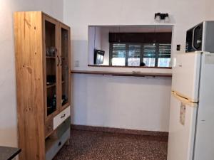 eine Küche mit einem weißen Kühlschrank und einem Holzschrank in der Unterkunft casa en escobar con cocheras in Belén de Escobar + 9 Fotos