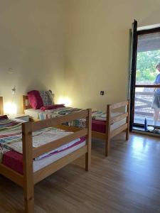 a bedroom with two bunk beds and a woman walking out the door at Németh Apartman Palić in Palić
